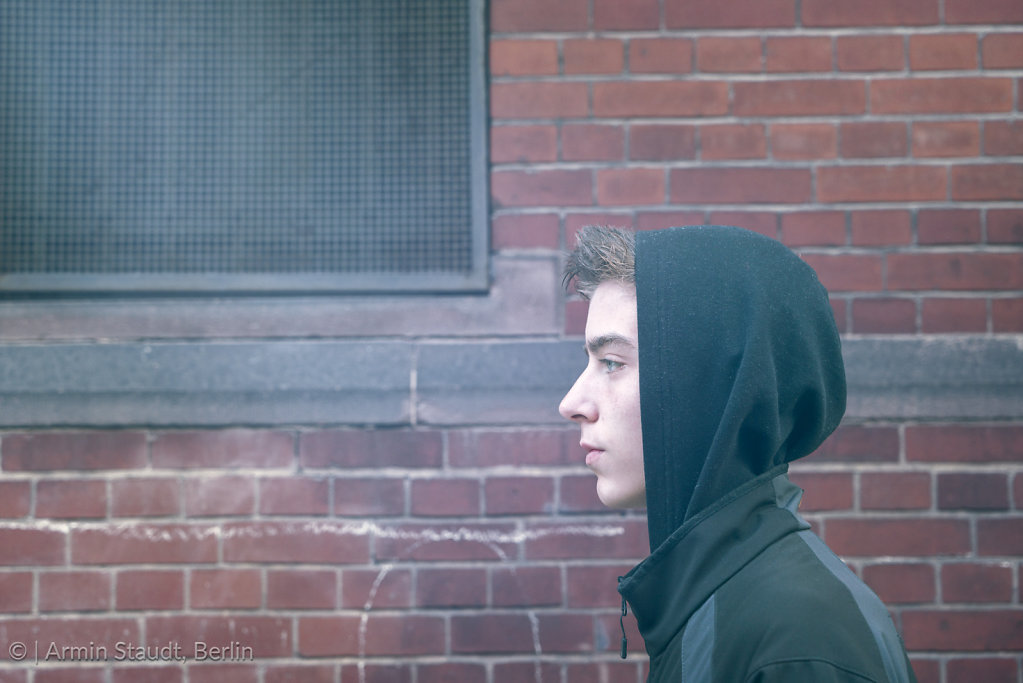 portrait of a young man in profile with hoodie