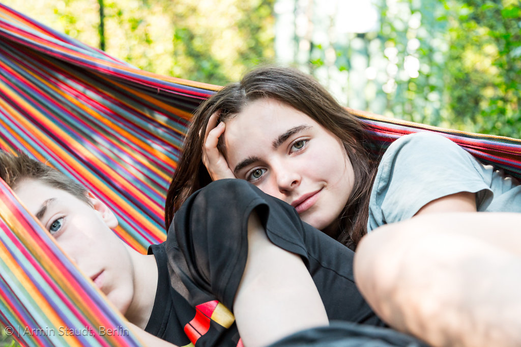 close up of two siblings laying in a hammock