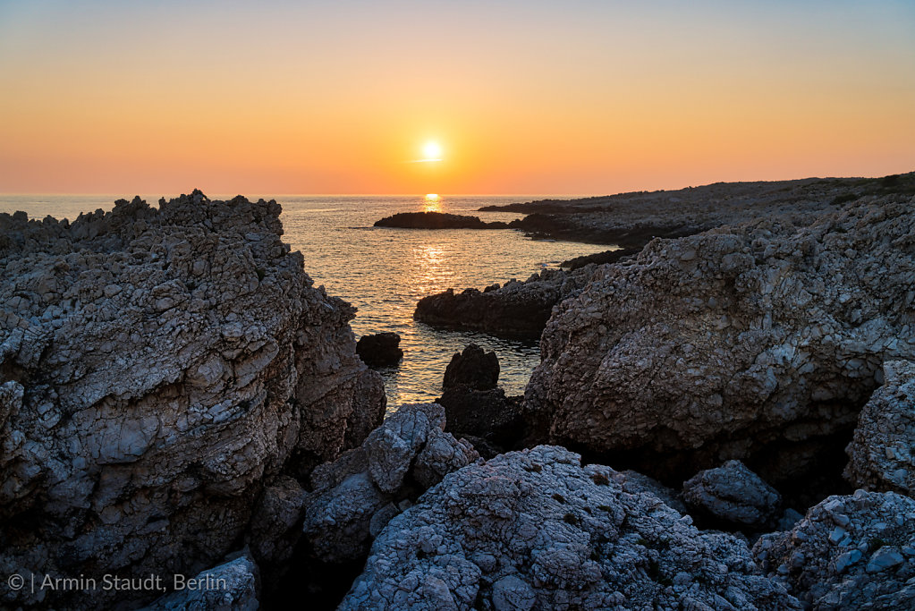 mediterranean landscape, sunset over a stony shore