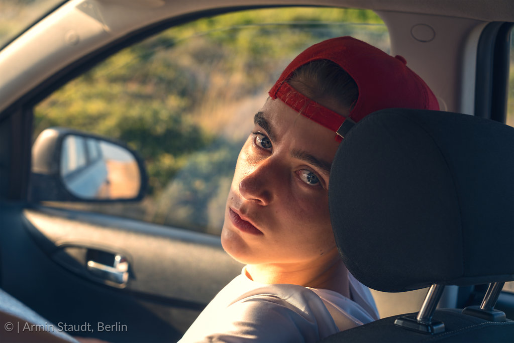 portrait of a young man, sitting in a car