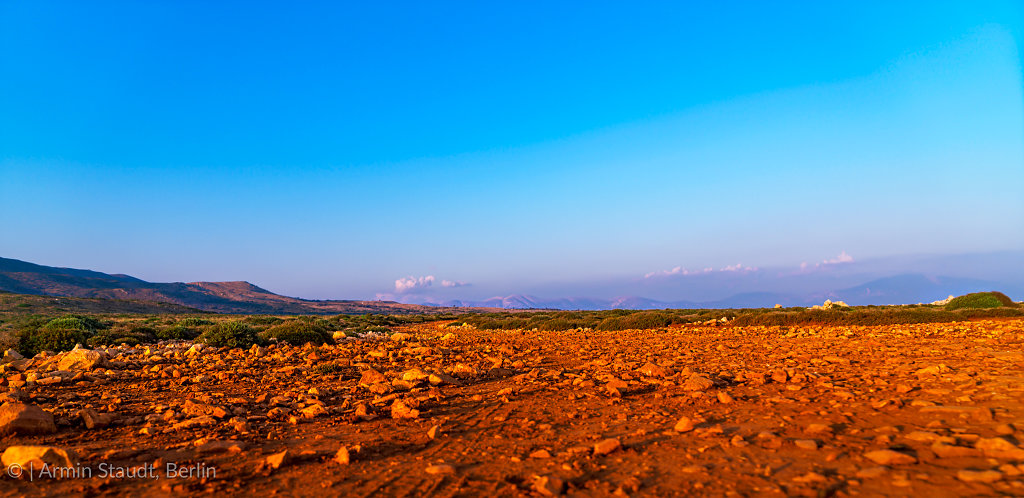 landscape in the evening with red stones and mountain range